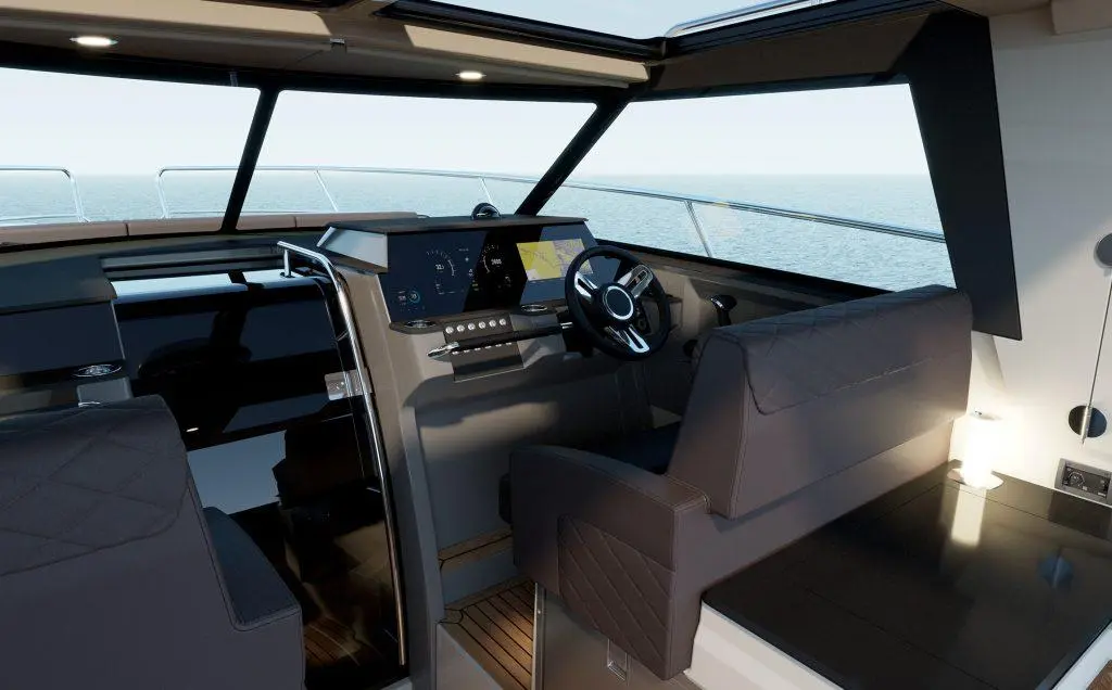 Interior of a modern boat helm, featuring a steering wheel, digital displays, and plush seating with a sea view.